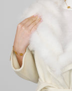 Close-up of a white fur collar, showing shoulder and neckline