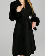 Woman wearing a long black coat, walking forward