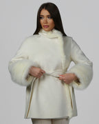 Woman wearing a white fur coat with full sleeves, front-facing