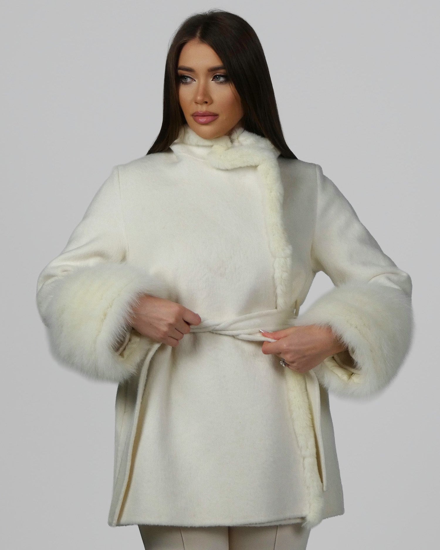 Woman wearing a white fur coat with full sleeves, front-facing