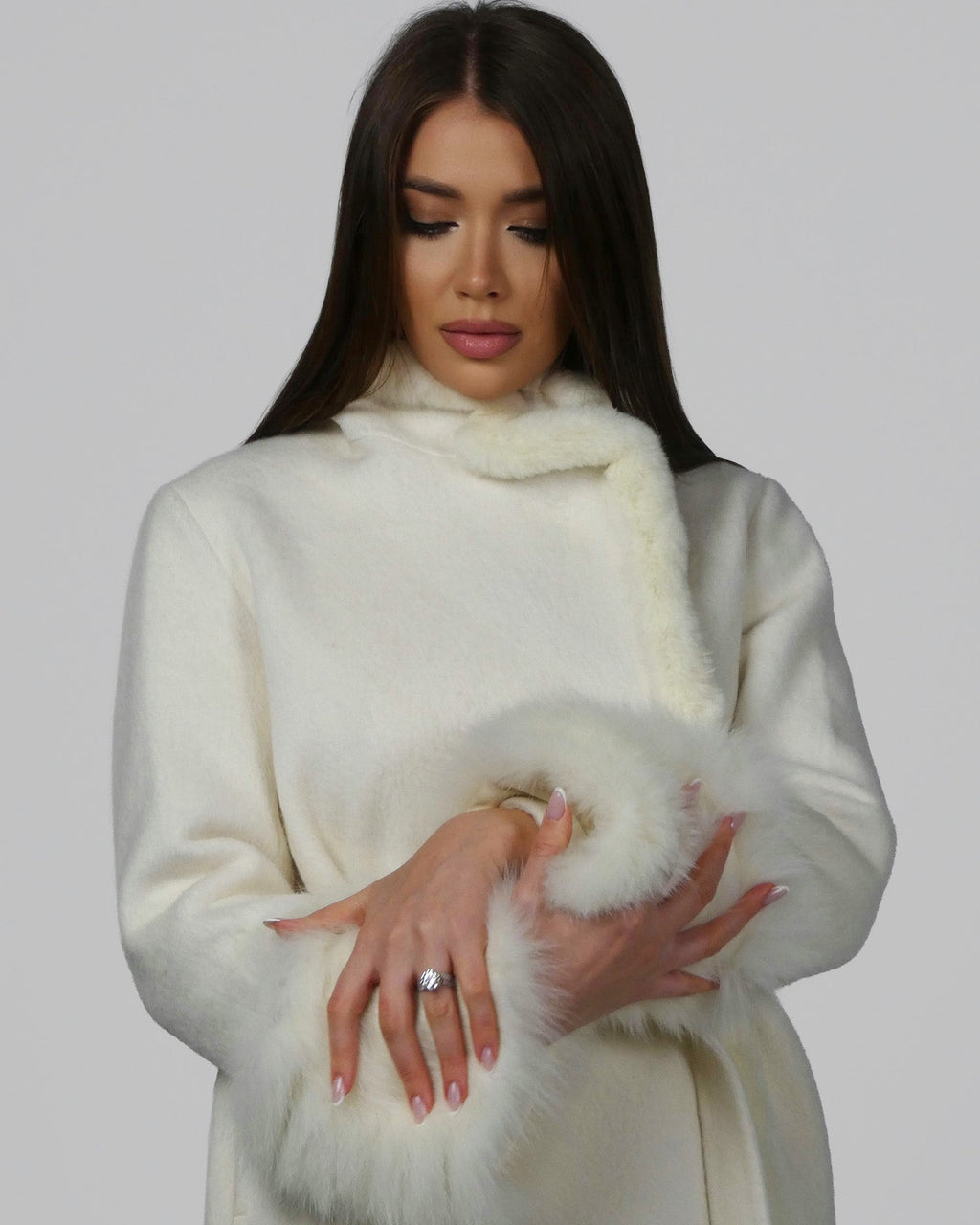 Woman wearing a white fur coat, showing the sleeve detail with one arm raised