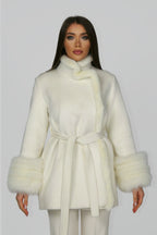 Woman wearing a white belted coat, facing forward