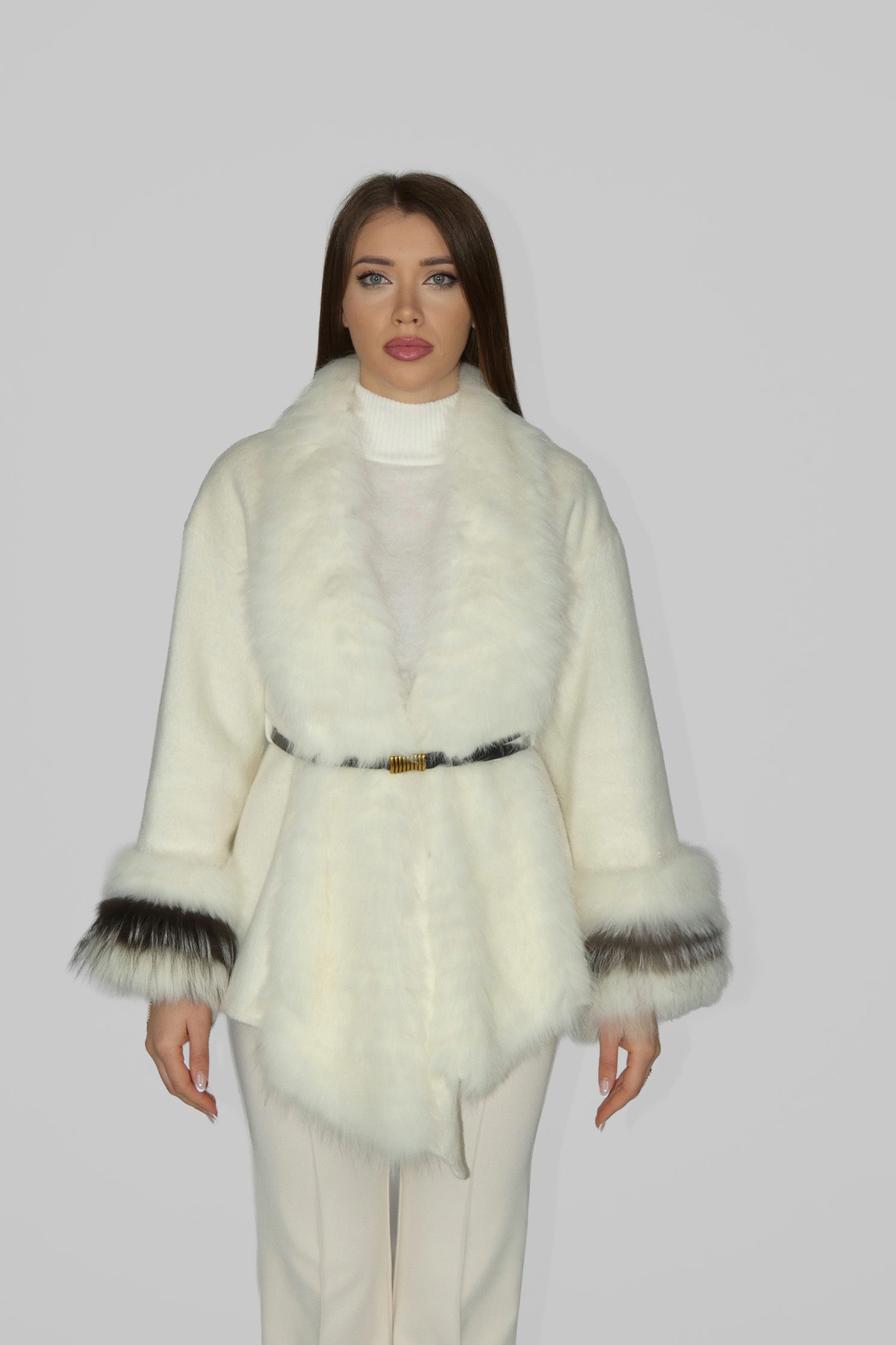 Woman wearing a white fur coat with black trim, facing forward