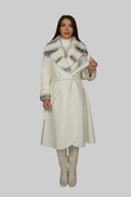 Woman wearing a long white coat, standing in a centered front pose