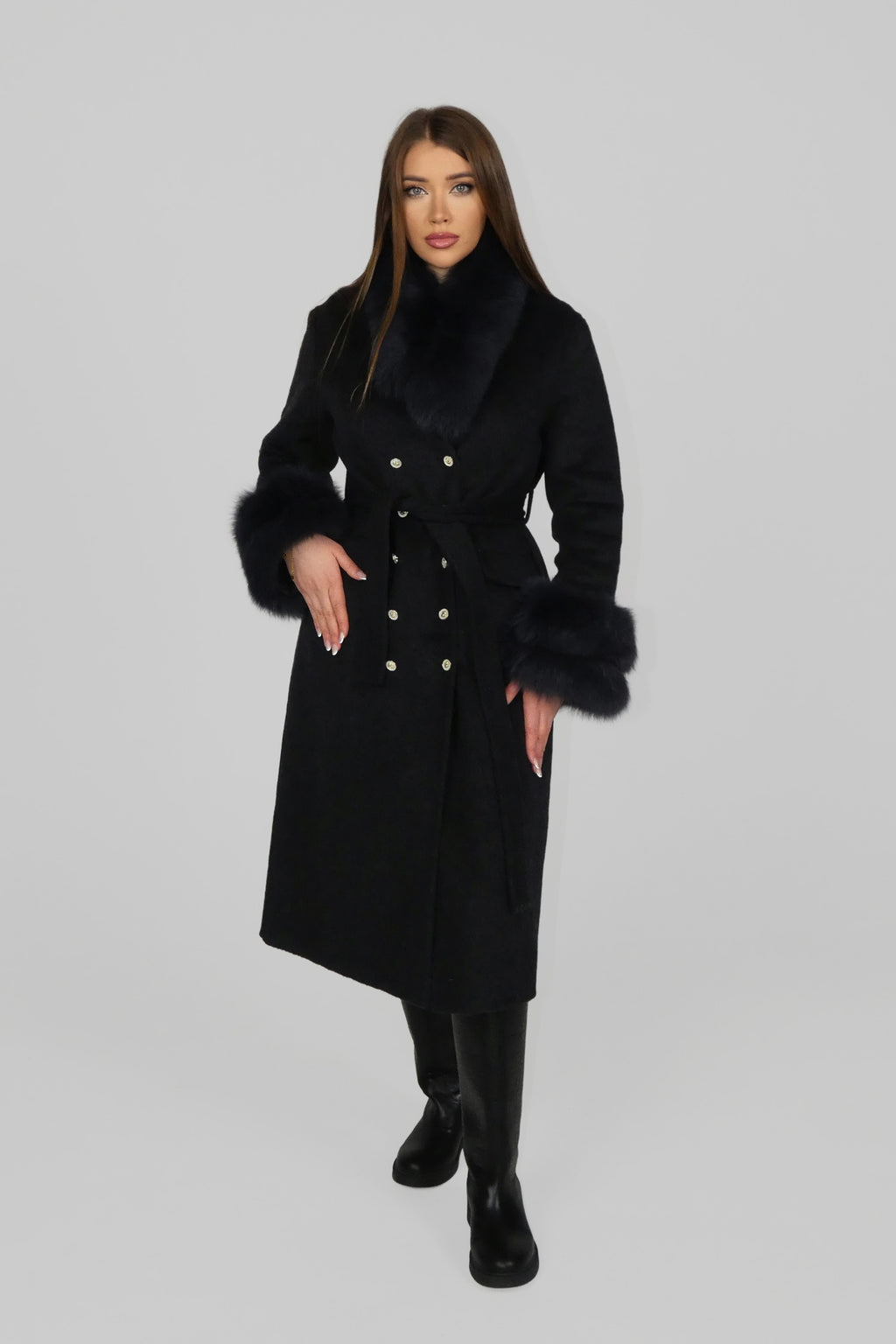 Woman wearing a long black coat, walking toward the camera