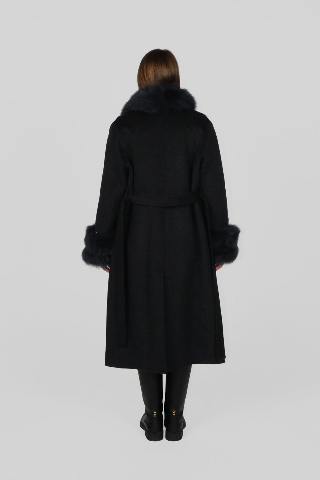 Back view of a long black coat shown on a standing model